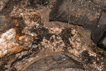 Closeup of a natural stone with black mossy stripes and orange colors