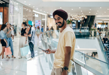 Portrait Of Happy Indian Man Using A Mobile Phone At The Shopping Mall