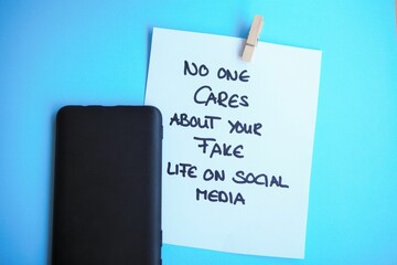 No one cares about your fake life on social media alongside a smartphone on a blue background