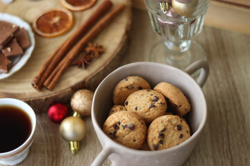 Cup of tea or coffee, various sweets and spices, Christmas decorations, comfy blanket, books and glasses. Selective focus.