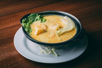 Closeup shot of a soup with shrimp and lettuce