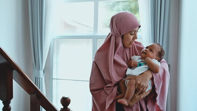 Thai Muslim young mother with her baby at home