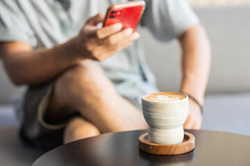 Fototapeta na wymiar Close-up of a man using a smartphone in a coffee shop.