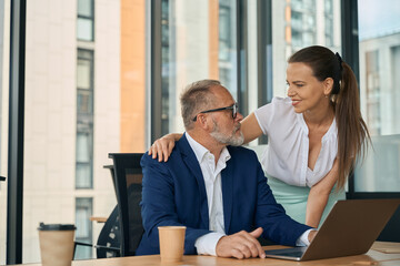 Woman and man with romantic relationship in office