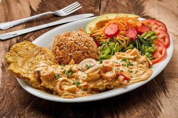 Plate with Pariser schnitzel, rice, and vegetables on a wooden table