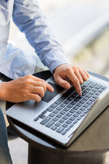 Side view of male businessman hands typing on laptop keyboard.