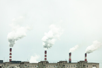 Fototapeta na wymiar industrial chimneys with heavy smoke causing air pollution on the gray smoky sky background 