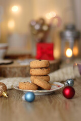 Various Christmas decorations, cup of tea or coffee, sweets, small presents, knitted blanket and candles. Selective focus.