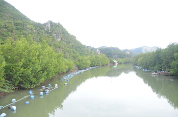 Thailändisches dorf am Jungle Ufer mit Wasserstraßen und Booten.