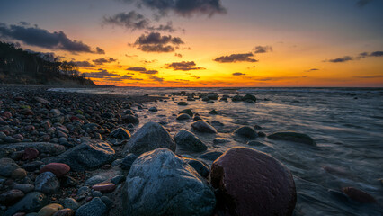 Wonderful orange sunset on the rocky coast of the sea