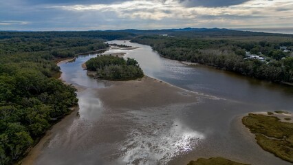 Aerial shot of the Lake Cathie surrounded by lush trees in New South West, Australia