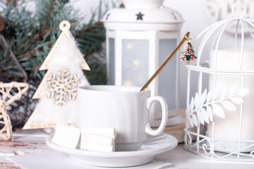 Christmas tree toys on the table with a cup of morning tea. Christmas background in white tones