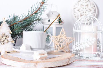 Christmas tree toys on the table with a cup of morning tea. Christmas background in white tones