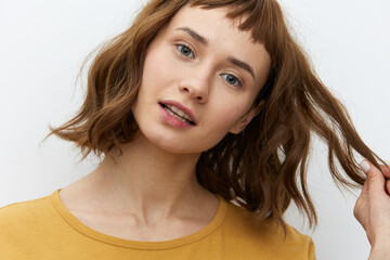 Naklejka premium a close, horizontal portrait of a happy, beautiful, attractive red-haired woman playfully pulling back a lock of her well-groomed hair