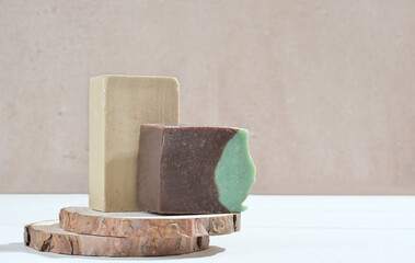 natural craft hand made soap bars on wooden podium, copy space. brown and baige solid hand soap made of organic ingredients.