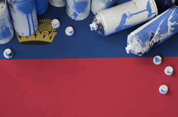 Liechtenstein flag and few used aerosol spray cans for graffiti painting. Street art culture concept