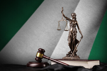 Nigeria flag with statue of lady justice, constitution and judge hammer on black drapery. Concept...