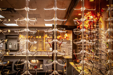 Looking in window of optical eyewear shop with fall decorations - Rows of acrylic stands displaying different styles
