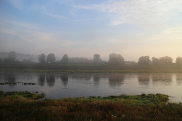 foggy morning over river in summer in countryside