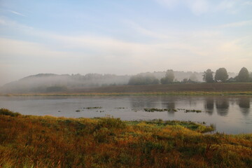 foggy morning over river in summer in countryside