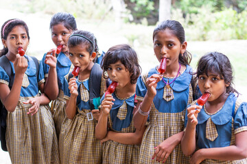 School Children's  eating an ice lolly in outdoot