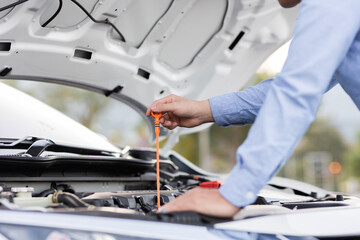 car mechanic Side view of mechanic checking engine oil level in car mechanic checking engine oil
