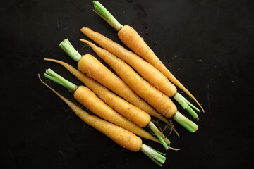 bunch of yellow baby carrots on a green background