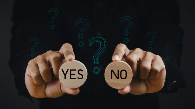 Think With Yes Or No Choice, Business Choices For Difficult Situations, Yes or no and question mark, man holding wooden with yes or no word on it, making decision.