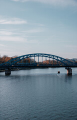Fototapeta na wymiar iron bridge over river with tram and autumn colors