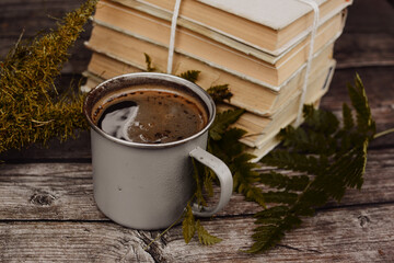 Old books and cup of coffee on dark wooden background