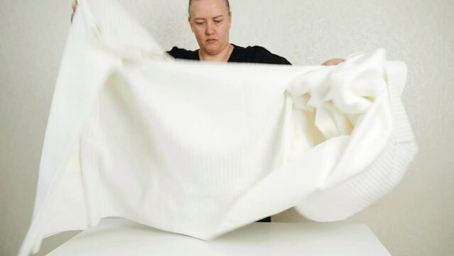 Work at home. Small business. A woman - a seamstress goes through the fabric before cutting, working at home.