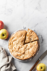 Traditional Charlotte apple cake with apples and rustic knife on white marbel background, apple pie top view, flat lay. Space for text