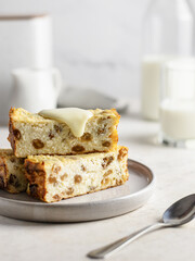 Cottage cheese or ricotta casserole or pudding with raisins poured with condensed milk on white table background