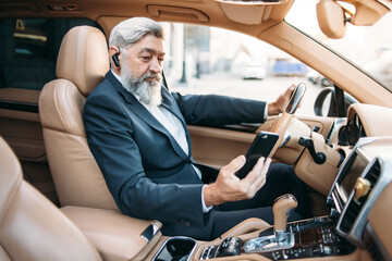Senior good looking businessman driving his car