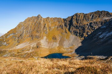 Obraz premium Scenic shot of mountains and fields surrounding the Heart (Herzsee) Lake in Austria