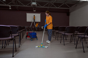 Dedicated cleaning company workers performing cleansing procedures in the office