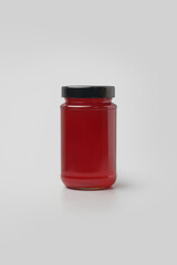 glass jar with bright red jam, bottle with black lid, isolated on neutral gray background, mock-up template