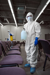 Cleaner wearing personal protective gear during disinfection of furniture