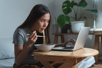 Freelancers eating instant noodles during work at night