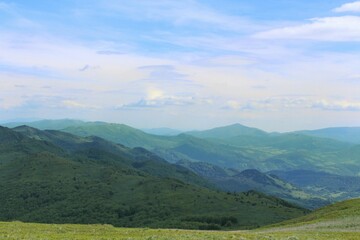 Fototapeta premium Beautiful shot of a green landscape under the white clouds
