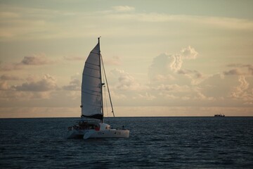 Boat in a calm water against clouds at sunset