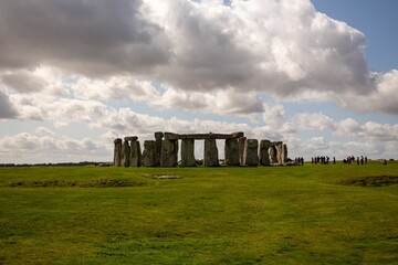 Stonehenge in the green meadows with a cloudy blue sky