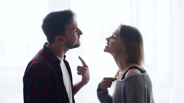 Millennial couple arguing shouting blaming each other of problem, frustrated caucasian man and annoyed caucasian woman quarreling about bad marriage relationships, unhappy family fighting at home 