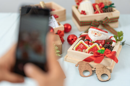 Person taking a picture of a set of boxes with christmas decoration objects