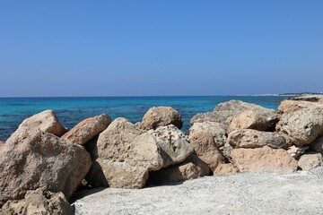 Rocky coast of the Mediterranean Sea in Cyprus under the blue sky