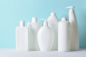 Plastic white bottles on a light blue background. Layout of bottles with household chemicals for cleaning and disinfection of the room