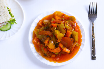 Spicy salad of carrots and peppers on a white plate. Shallow depth of field