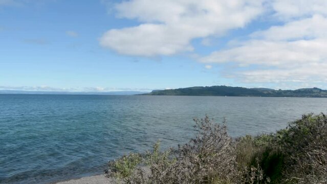 Drone shot of Taupo lake with the water moving from wind, clear sky background