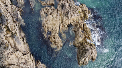 A lot of boulders in the sea water. Coastal cliffs of the North Atlantic. Seaside beautiful nature. Dramatic seascape of the north of Europe. Aerial photo.