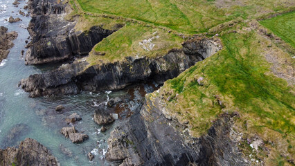 Rocky shores of the Celtic Sea along the route of the Wild Atlantic Way, top view. Seascape of the southern coast of Ireland. Beautiful rocky slopes.